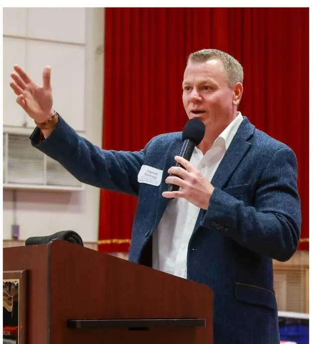 Daniel Ramsey speaking at the podium during the 2025 Christmas Fundraiser